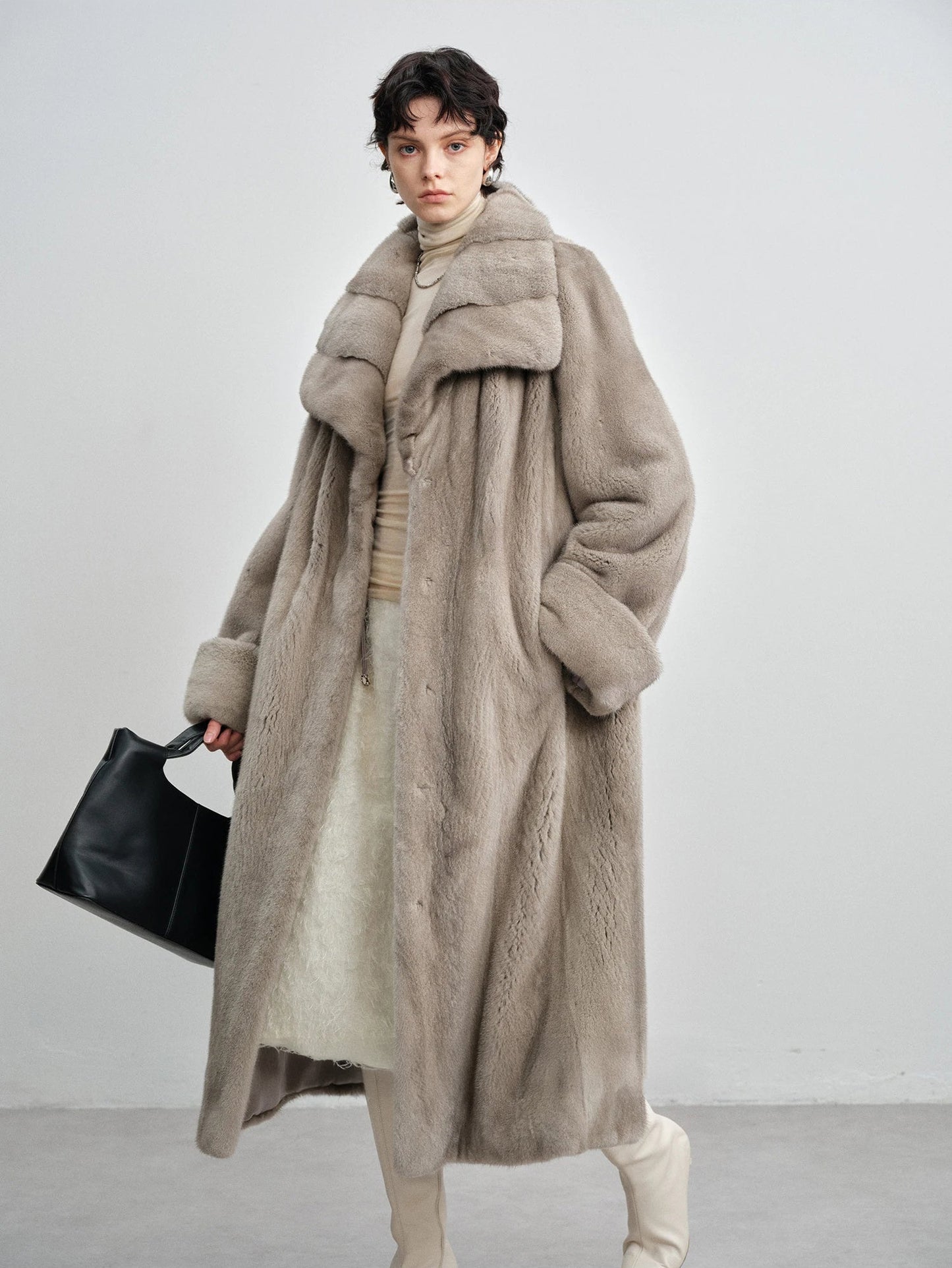 Model holding a black handbag while wearing the wide lapel silver blue mink coat — From Borcelleclothes.