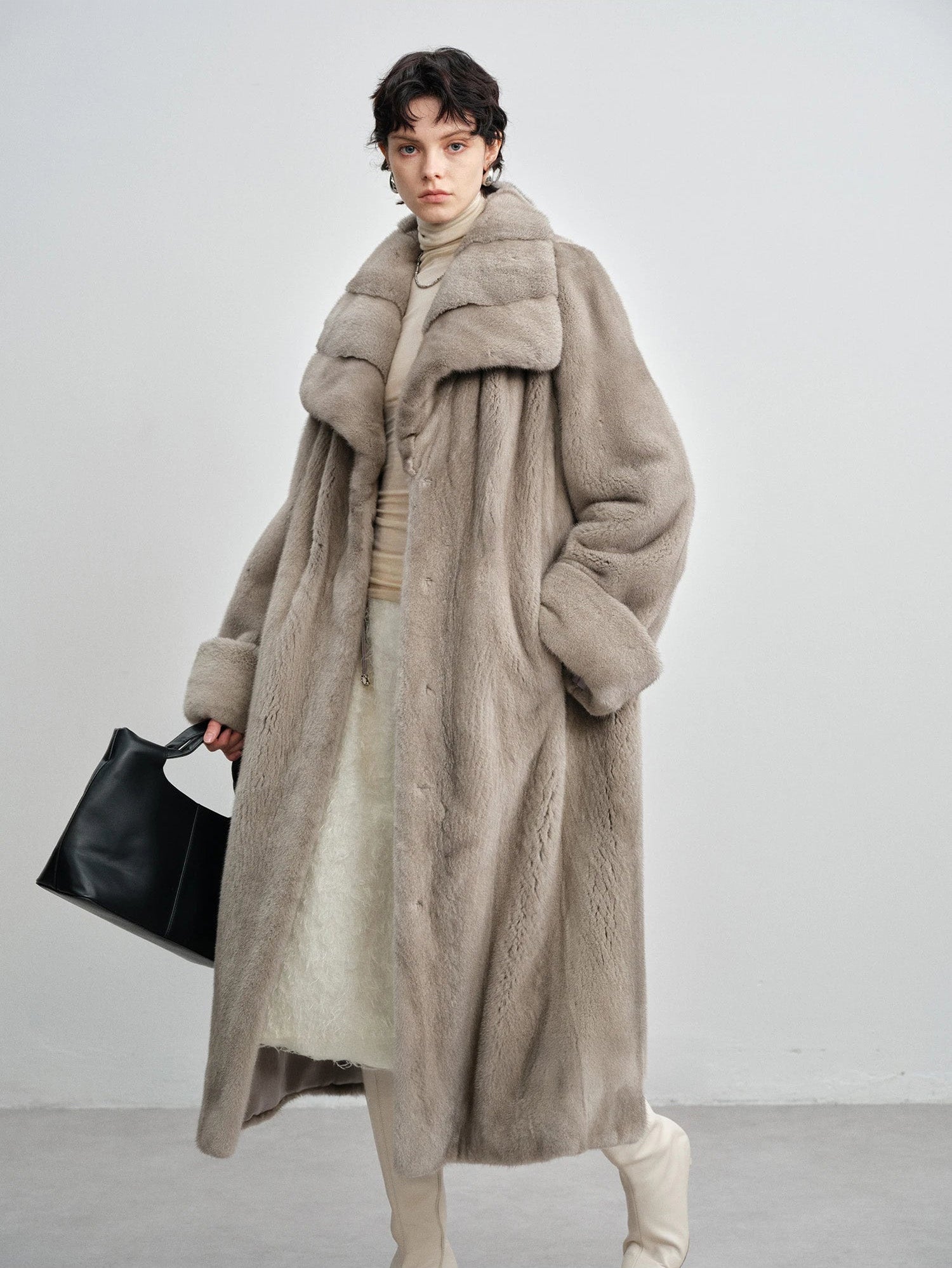 Model holding a black handbag while wearing the wide lapel silver blue mink coat — From Borcelleclothes.