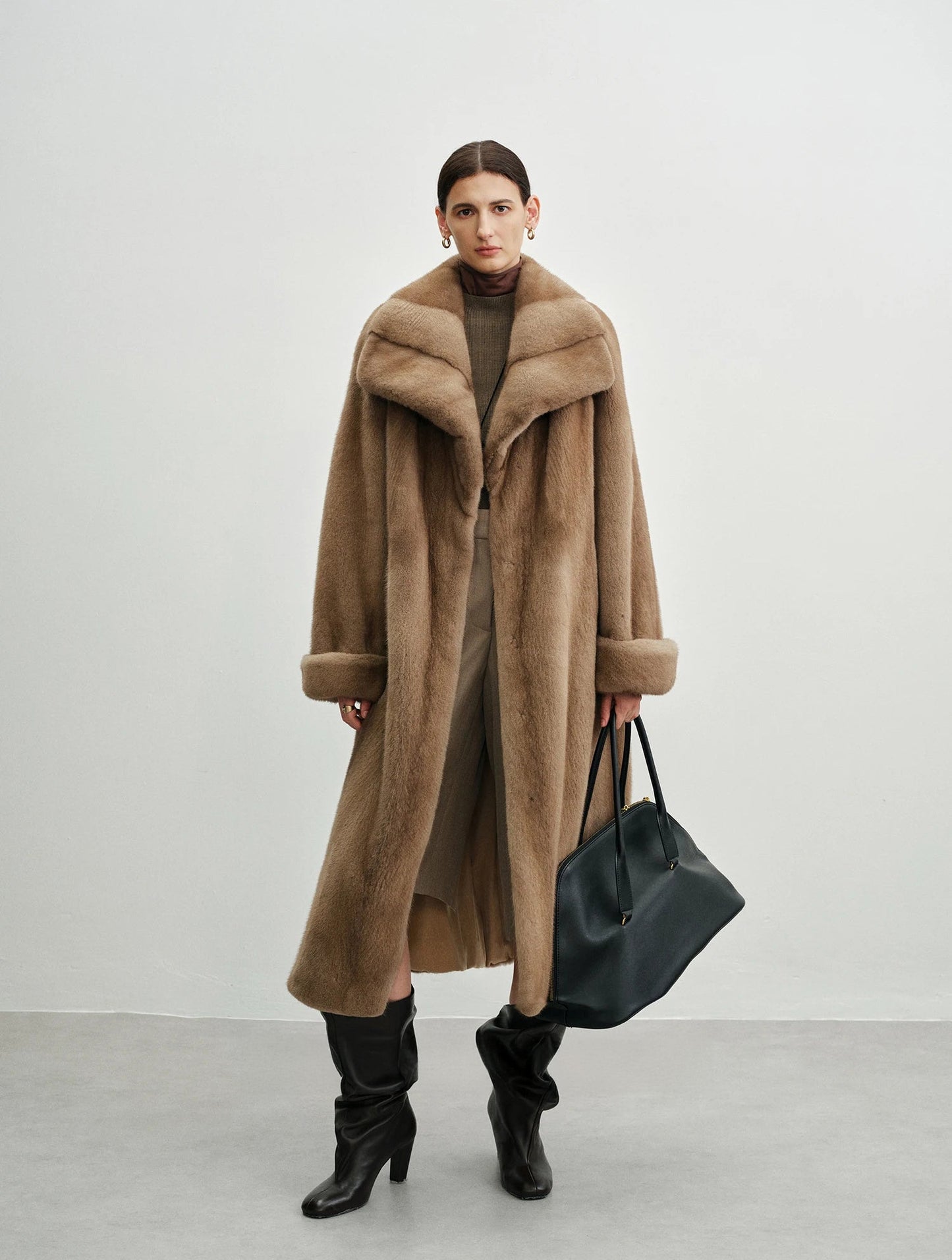 Model holding an oversized bag in the striped mink coat — From Borcelleclothes.