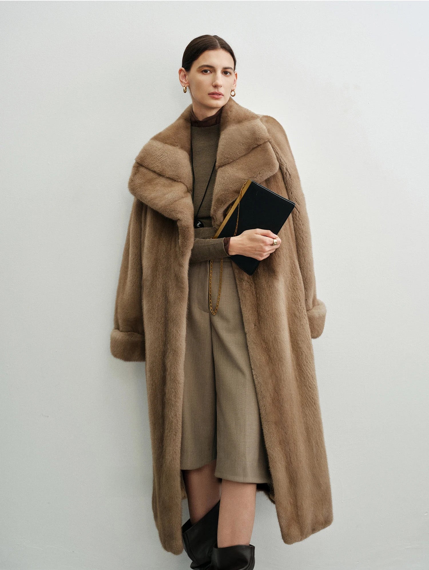 Model holding a small handbag in the striped mink coat — From Borcelleclothes.