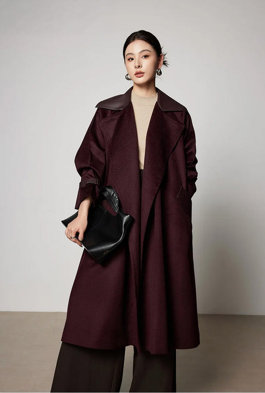 Full-length view of a model in the Dégustation wool coat holding a minimalist bag, highlighting the flared silhouette. From Borcelleclothes.