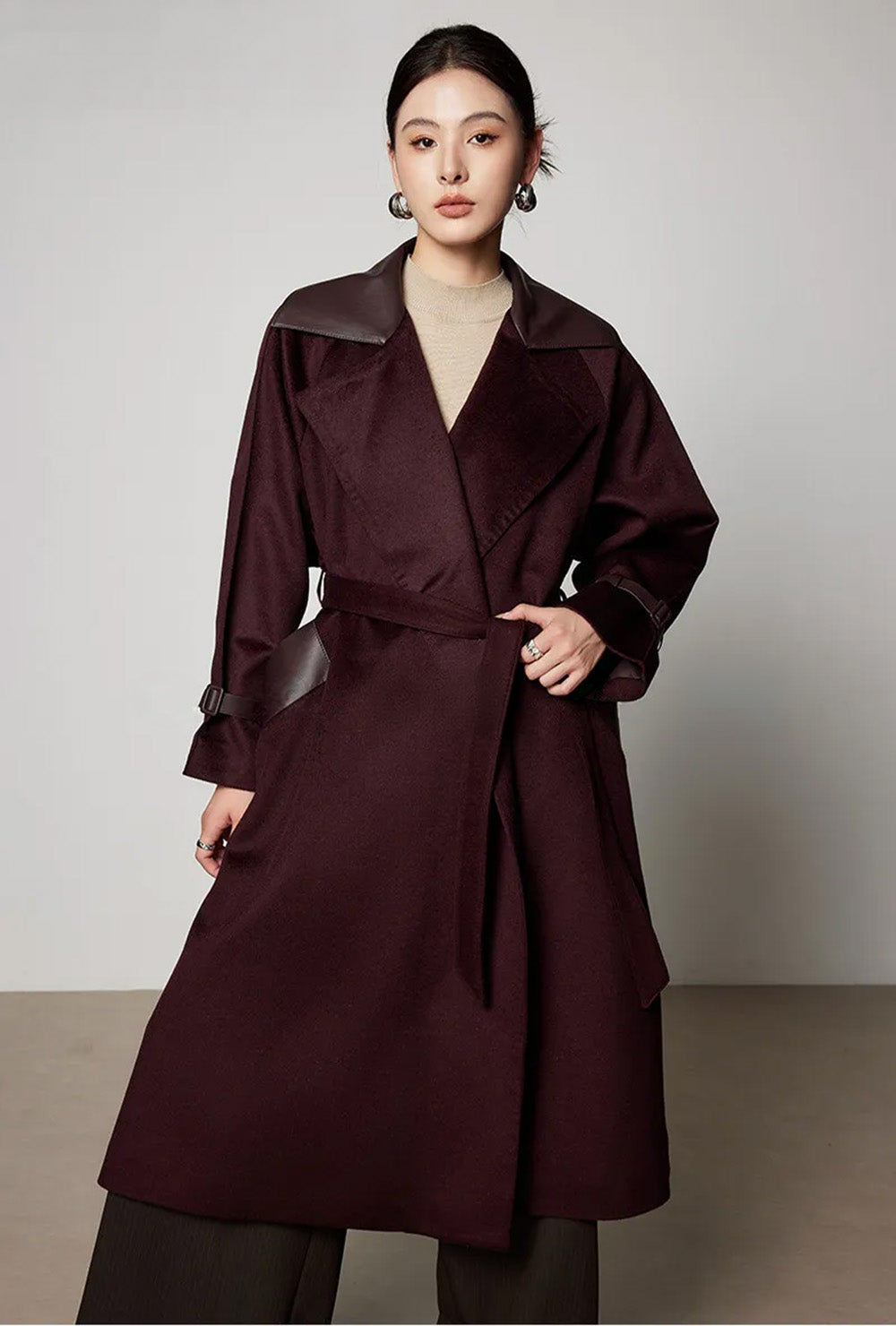 Model adjusting the self-tie wool belt, emphasizing the defined waist and fabric grain. From Borcelleclothes.