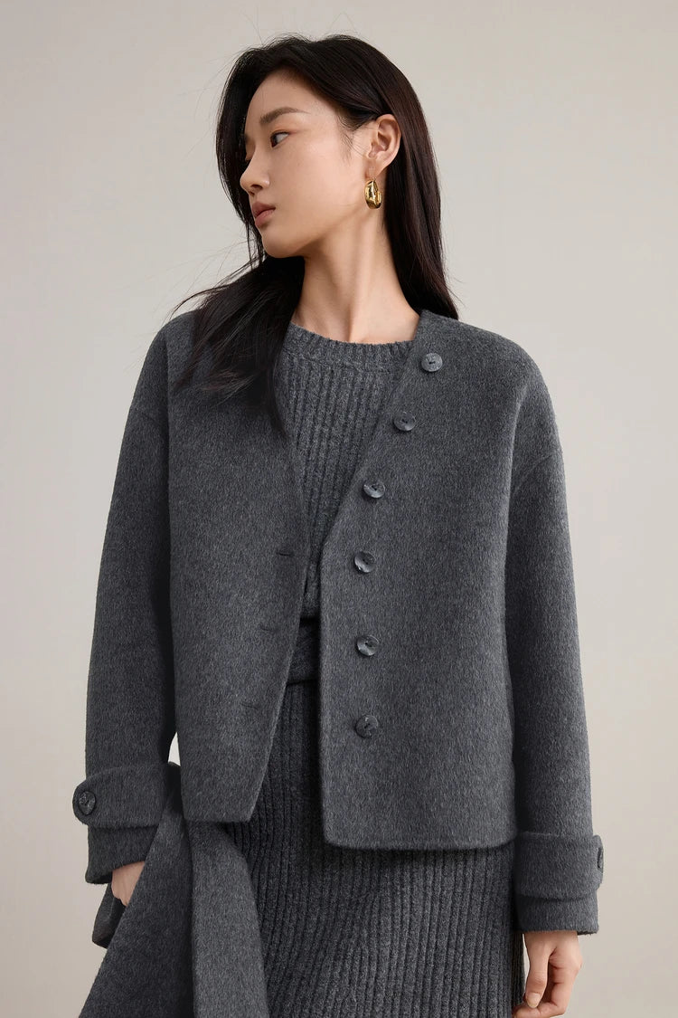 A thoughtful moment of a woman holding the detached grey scarf in her hand — From Borcelleclothes.