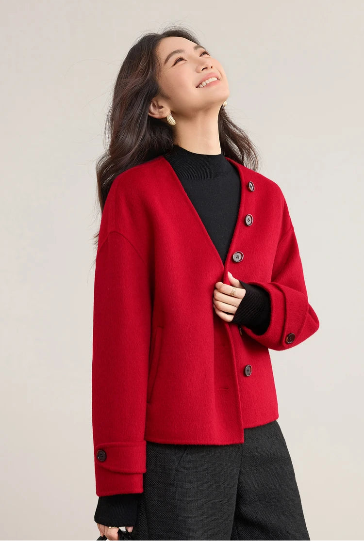 A woman looking up confidently, highlighting the graphic V-neckline of the red jacket without the scarf — From Borcelleclothes.