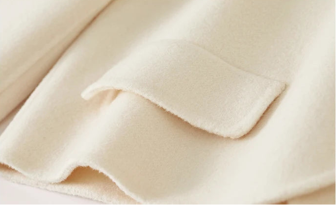 Detailed view of the minimalist side decorative flap and the seamless hand-finished edge — From Borcelleclothes.