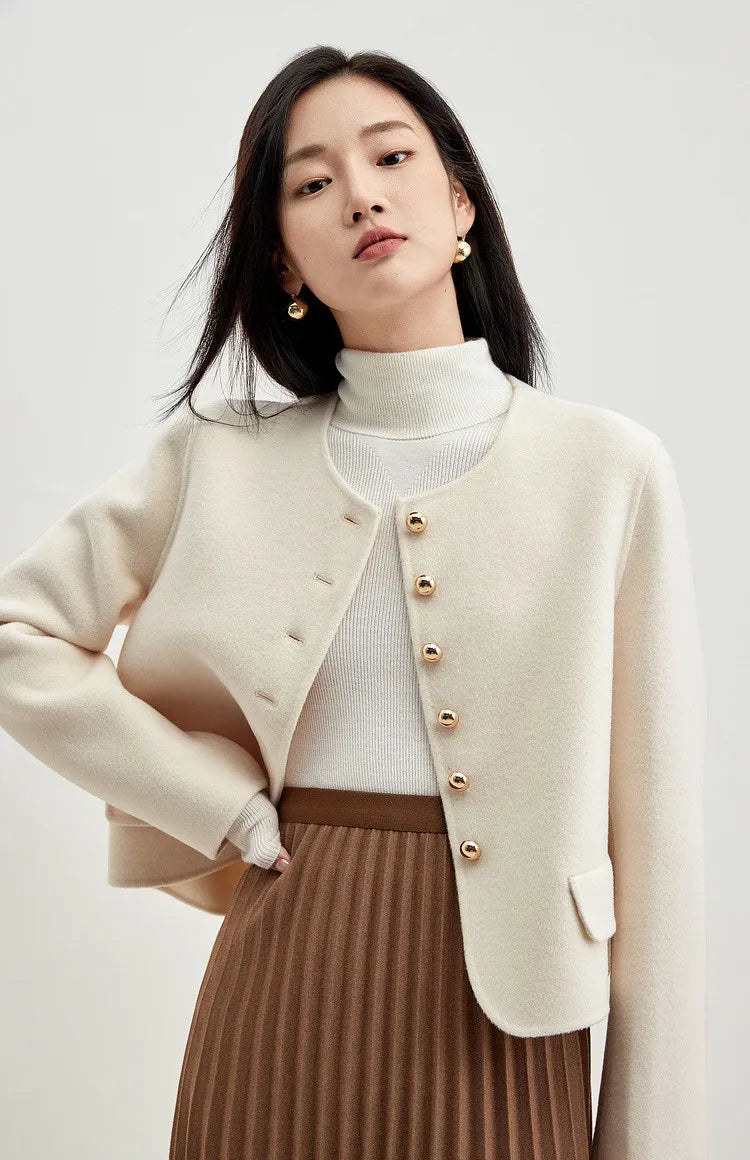 Confident woman looking straight ahead in a cream wool jacket, featuring a structured yet fluid fit — From Borcelleclothes.