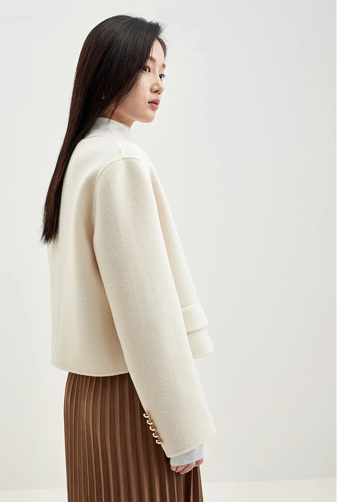 Side profile of a woman in a cream wool jacket, emphasizing the clean, collarless neckline and soft tailoring — From Borcelleclothes.