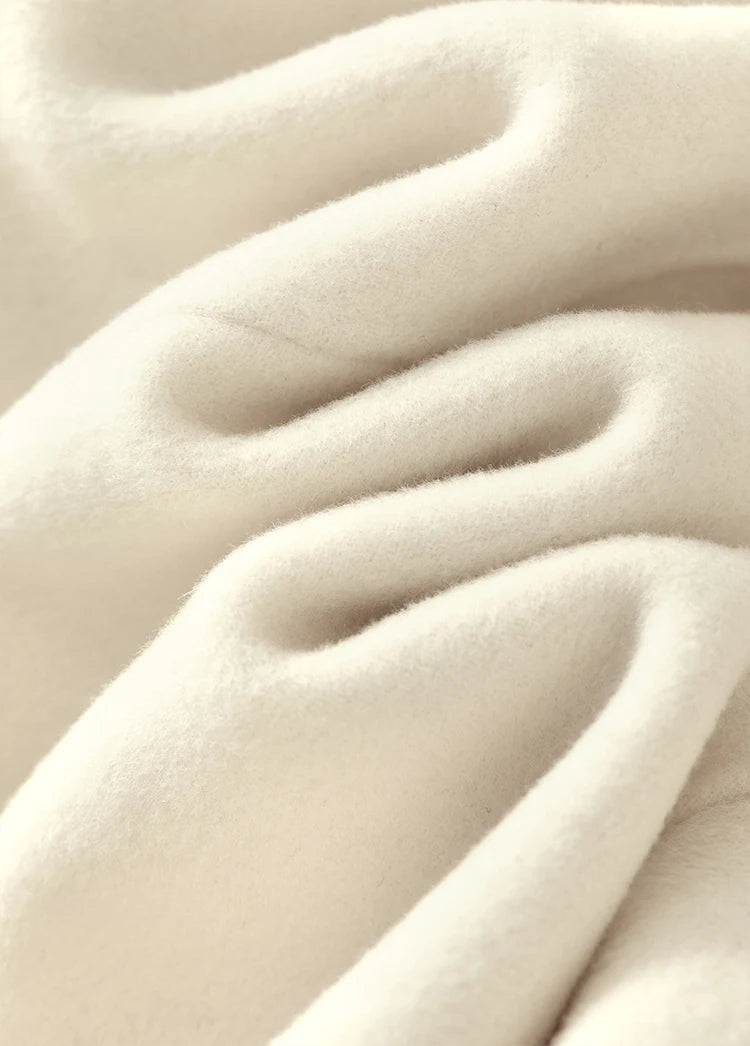 Close-up of the cream wool fabric’s wave-like texture, highlighting its natural density and softness — From Borcelleclothes.