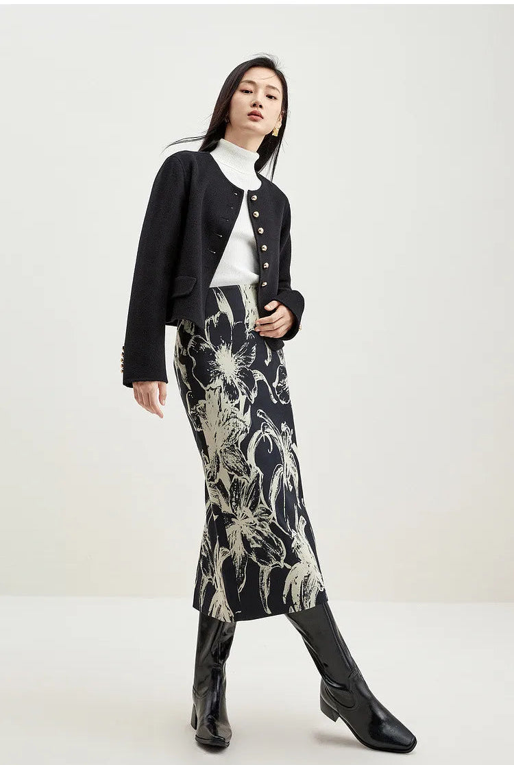 Sophisticated woman sitting with crossed legs in a black wool jacket, showcasing its hip-length silhouette — From Borcelleclothes.