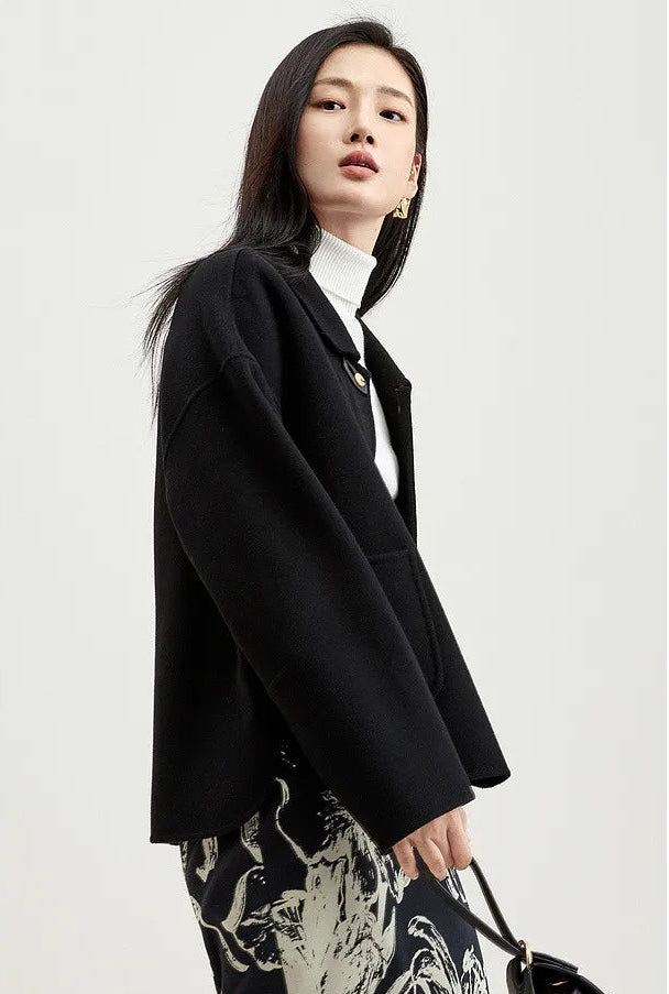 Side view of a model in a black women's wool jacket with graphic loop detail — From Borcelleclothes.