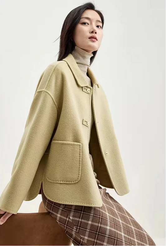 Model perched on the back of an armchair in a women's wool jacket with graphic loop detail — From Borcelleclothes.