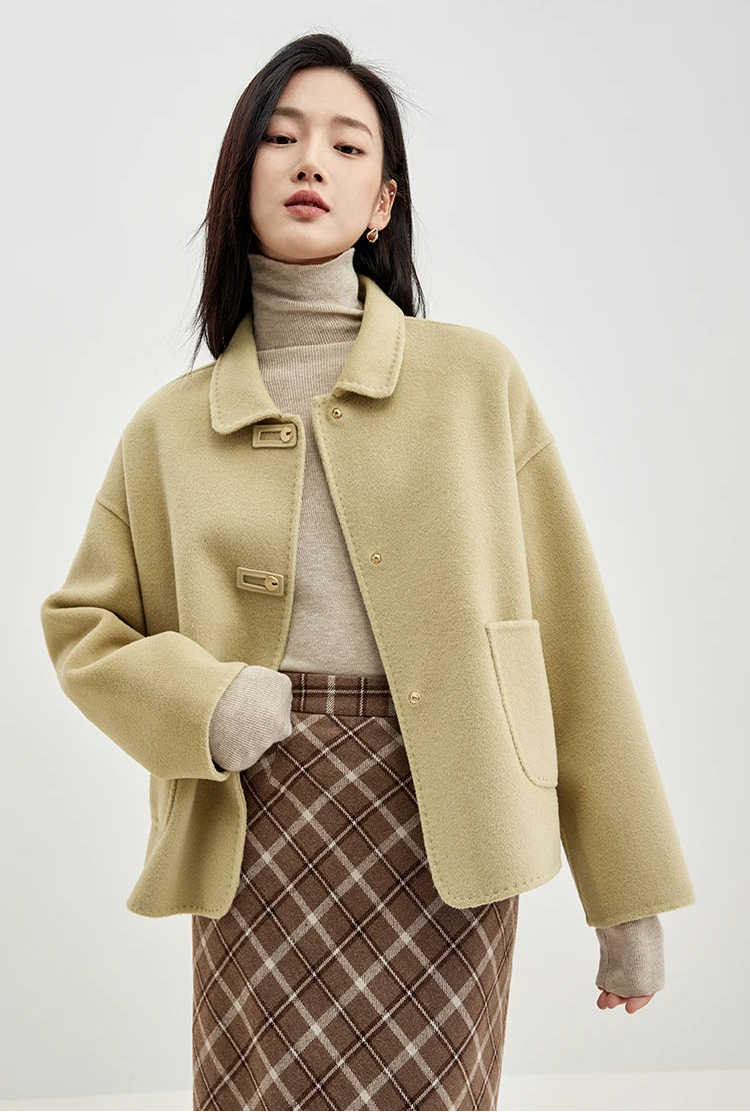 Unfastened wool jacket with graphic loop detail on a model with a bent arm — From Borcelleclothes.
