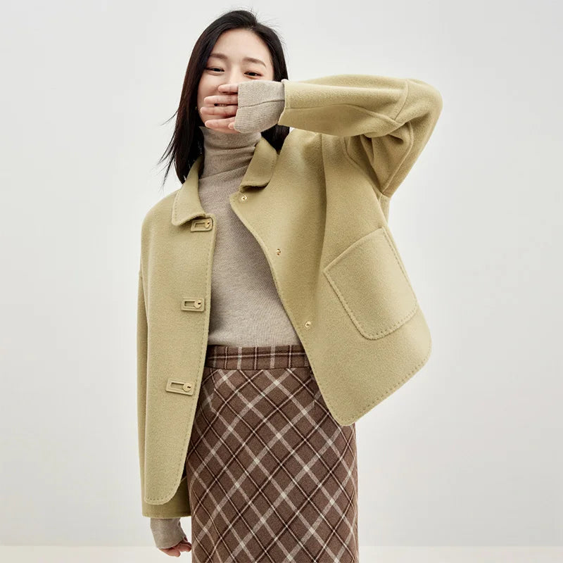 Women's double-sided wool jacket in Willow Catkin color, featuring decorative rectangular loops, golden C-shape snaps, and a softly arched side hem. — From Borcelleclothes.