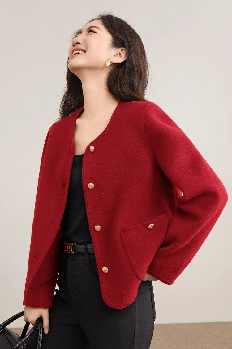 A smiling woman looking up while wearing the Betta Crimson wool jacket, capturing the light on the rich red virgin wool. — From Borcelleclothes.