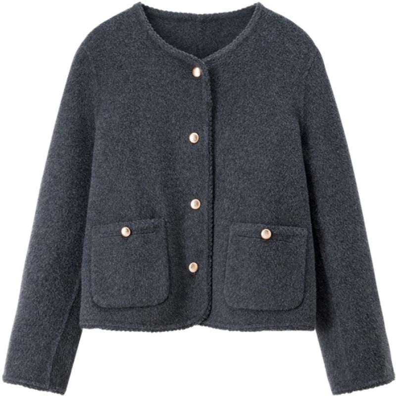 Front view of the Perle Noir wool jacket with gold-tone embossed buttons and signature Wave Stitch finishing on a flat surface. — From Borcelleclothes.