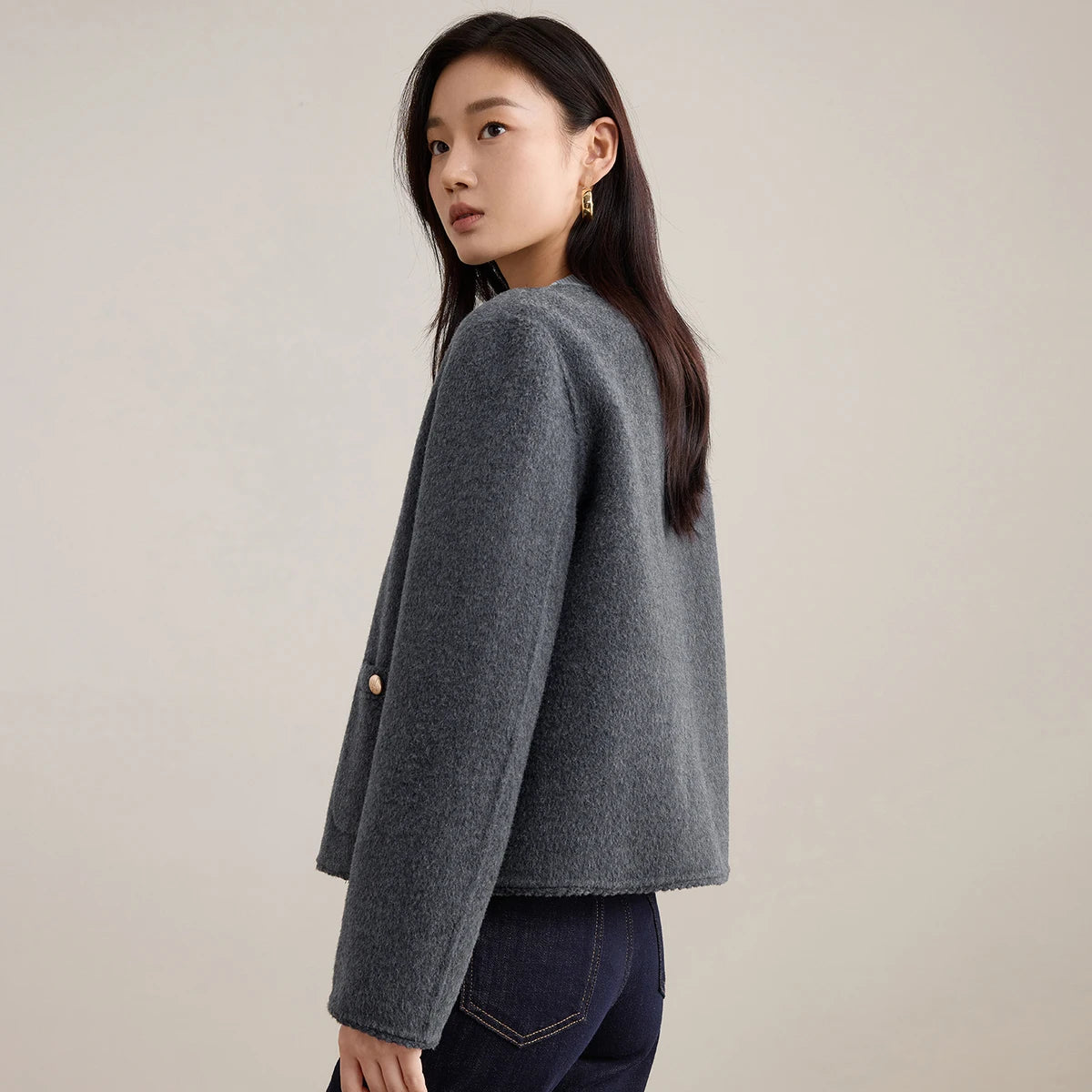Side profile of a woman in the Perle Noir wool jacket, emphasizing the natural flow and density of the double-faced wool. — From Borcelleclothes.