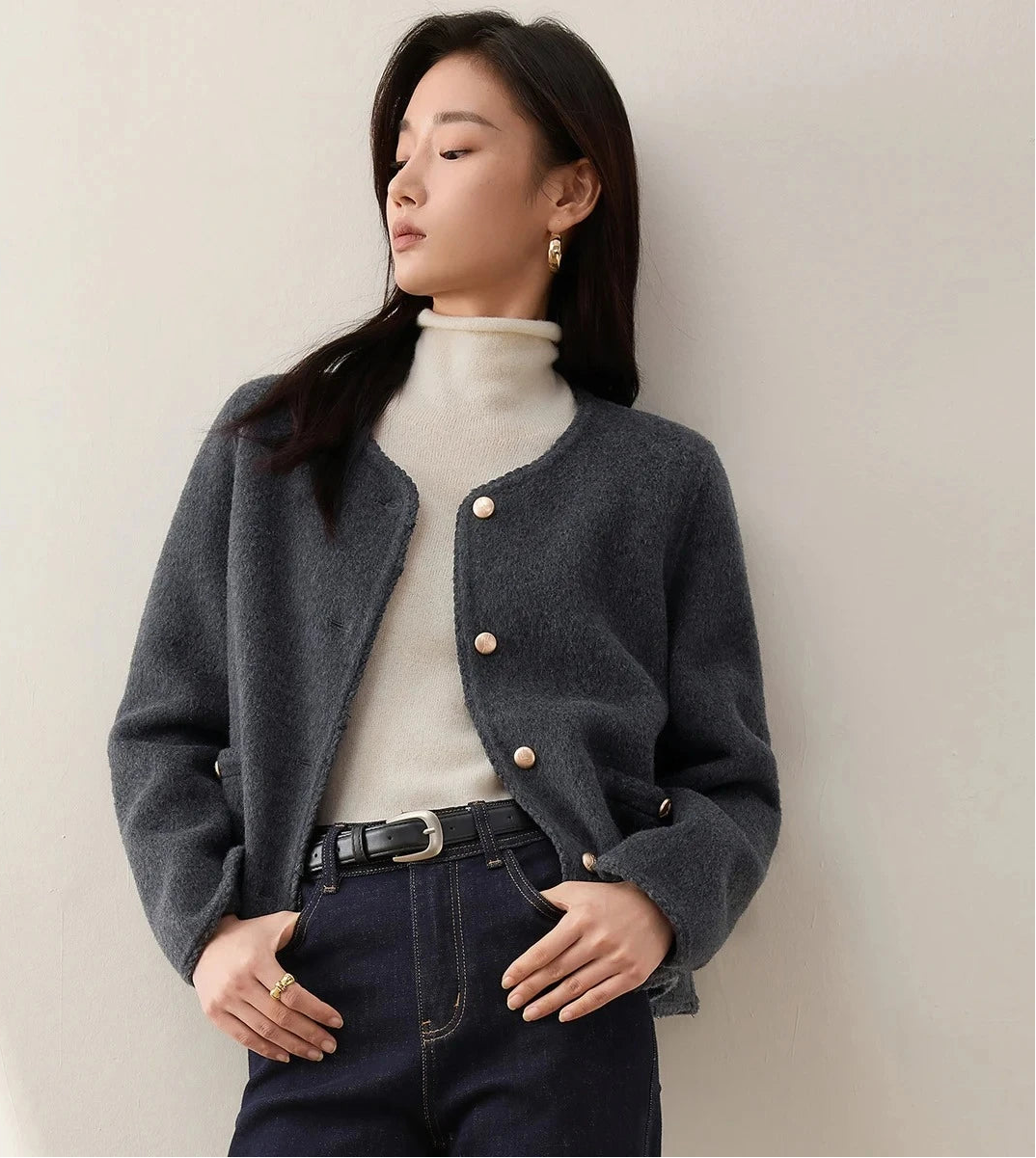 A woman wearing an unfastened Perle Noir wool jacket paired with jeans, highlighting the relaxed yet structured silhouette of the virgin wool. — From Borcelleclothes.