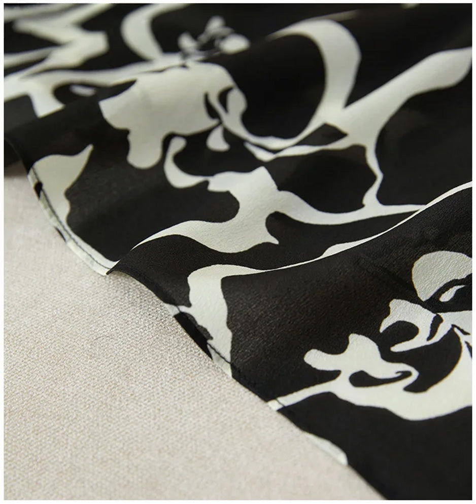 The sweeping bottom hem of the midi skirt, where the large-scale abstract flowers finally reveal their full, majestic form. — From Borcelleclothes.