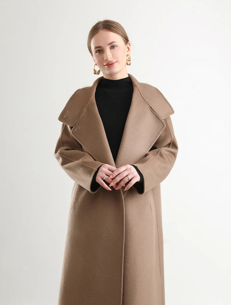 A close-up of a woman’s fingertips meeting over the Allspice wool from Borcelleclothes, a tactile moment that speaks of the fabric’s artisanal quality.