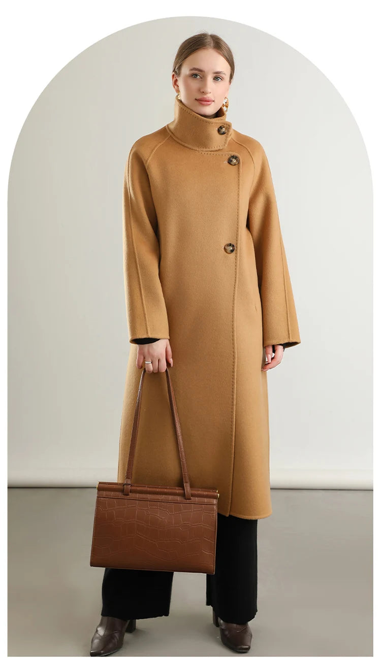 A harmonious look as a woman holds a matching bag, the Camel Train coat from Borcelleclothes embodying endurance and classic style.
