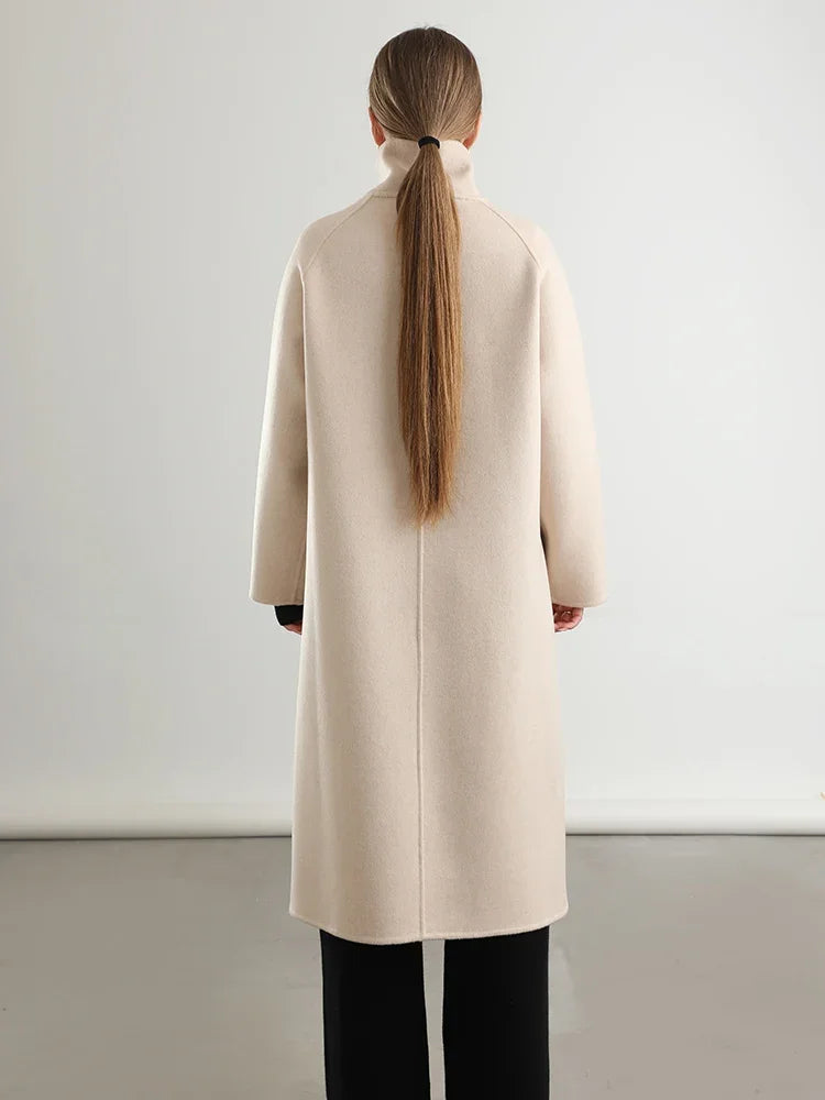The elegant, seamless back of the Ivory Route coat from Borcelleclothes, following the natural movement of a woman in motion.