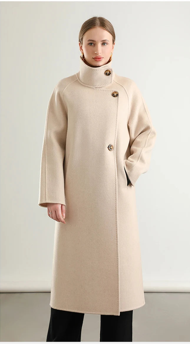 Captured in a relaxed stance, a woman rests her hand in the discreet pocket of her Ivory Route coat from Borcelleclothes, highlighting its sculptural yet effortless silhouette.