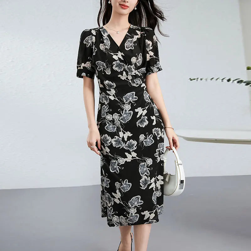 A women's midi-length wrap silk dress in "Drifting Blossom" print, featuring a floral Guohua painting design on a textured black double crepe background with short gathered sleeves and a side-tie waist. — From Borcelleclothes.