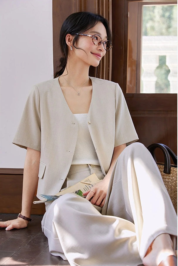 Woman in the alabaster two-piece set seated on the floor in a relaxed pose. From Borcelleclothes.