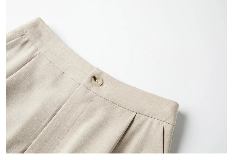 Close-up of the trousers’ waistband, showing a buttoned closure. From Borcelleclothes.  