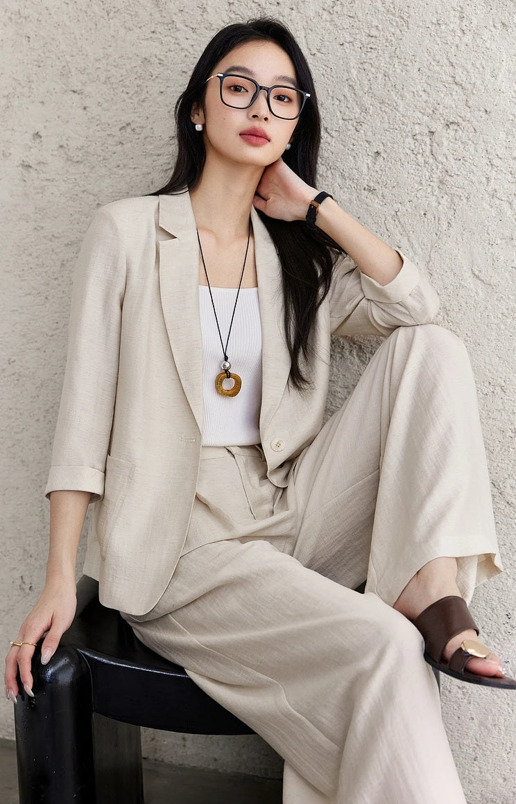 Model seated in the Bon Jour two-piece set, capturing the drape and neutral elegance of the fabric. From Borcelleclothes.