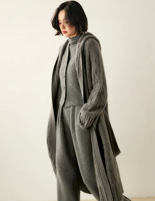Side view of a model wearing the women's Cable-Knit Cashmere Wool Coat in Flint, showcasing the intricate cable patterns and modern silhouette, Borcelleclothes.