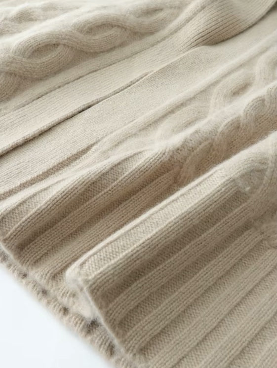 The wide ribbed bottom hem of the women's Cable-Knit Cashmere Wool Coat in Pearl Bush, emphasizing its structured and elegant finish, Borcelleclothes.
