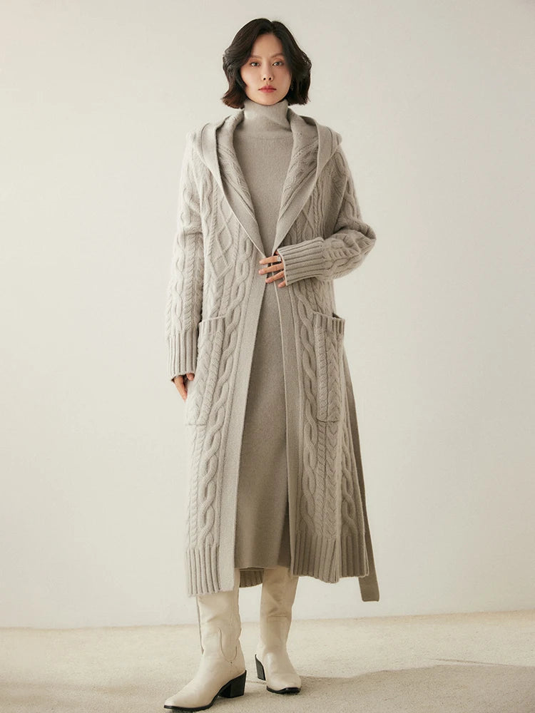 Model holding the front plackets of the women's Cable-Knit Cashmere Wool Coat in Pearl Bush, showcasing its cable-knit design and modern silhouette, Borcelleclothes.