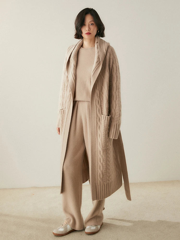 Model with one foot forward, wearing the women's Cable-Knit Cashmere Wool Coat in Soft Amber, highlighting its cable-knit patterns and contemporary elegance, Borcelleclothes.