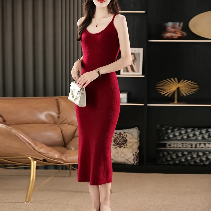 Woman holding a small handbag while wearing a Claret ankle-length wool camisole dress with slender straps and a sleek silhouette. From Borcelleclothes.