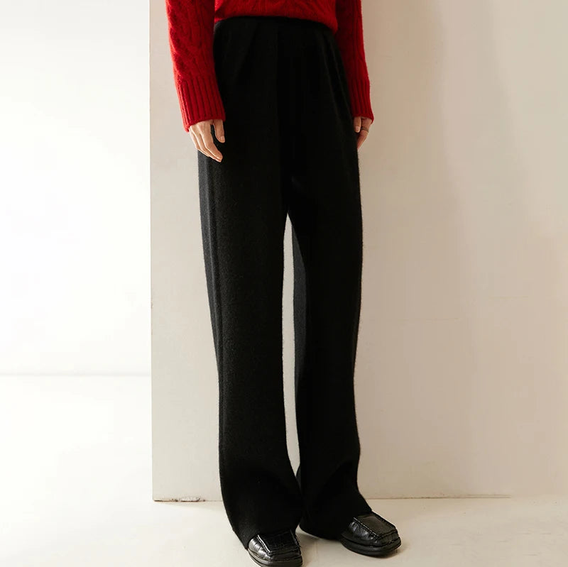 Model turned slightly to the side in Onyx pleated cashmere trousers — From Borcelleclothes.