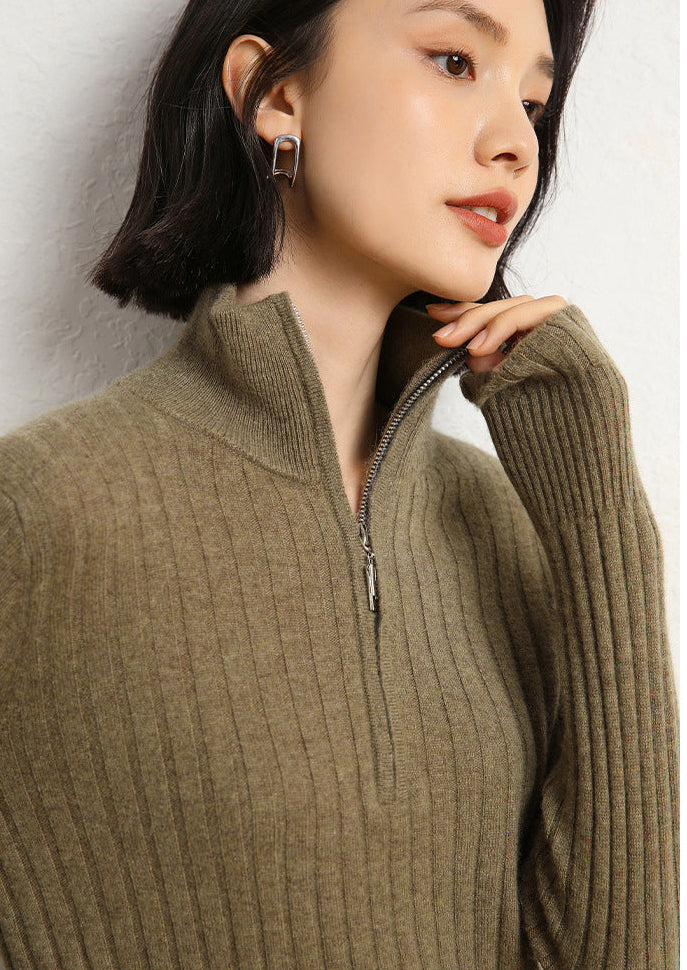 Model touching her chin wearing a Women’s cashmere half-zip sweater in Ivy Olive, featuring shifting rib textures, with stand collar and sculpted finish at hem and cuffs — From Borcelleclothes.