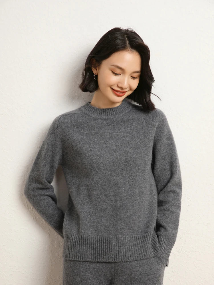 Woman in Dove Grey cashmere sweater with one arm behind her back – From Borcelleclothes.