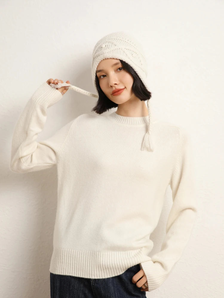 Woman in White Chocolate cashmere sweater raising the tie of a white hat – From Borcelleclothes.