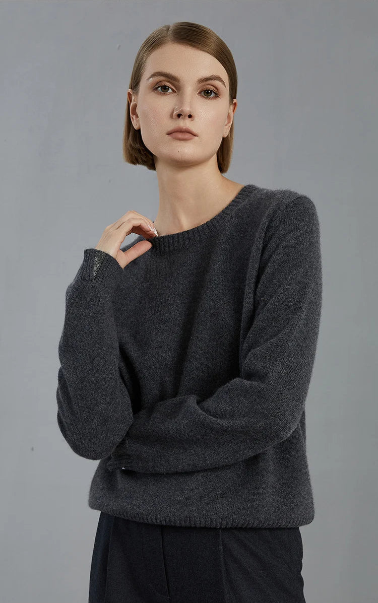 Model in Baltic Sea sweater gently touching the neckline, drawing attention to the fine rib texture — From Borcelleclothes.