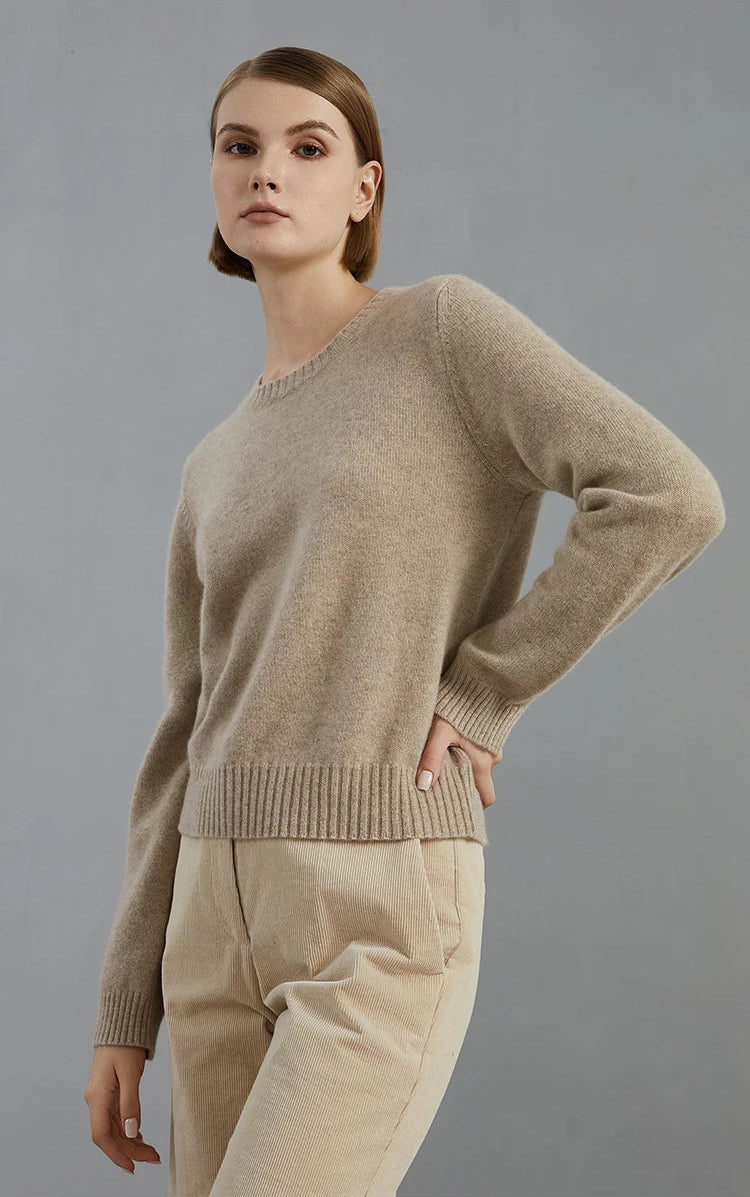 Model’s hand at the waist, highlighting the fitted silhouette and cuff detail of the Sandrift sweater — From Borcelleclothes.