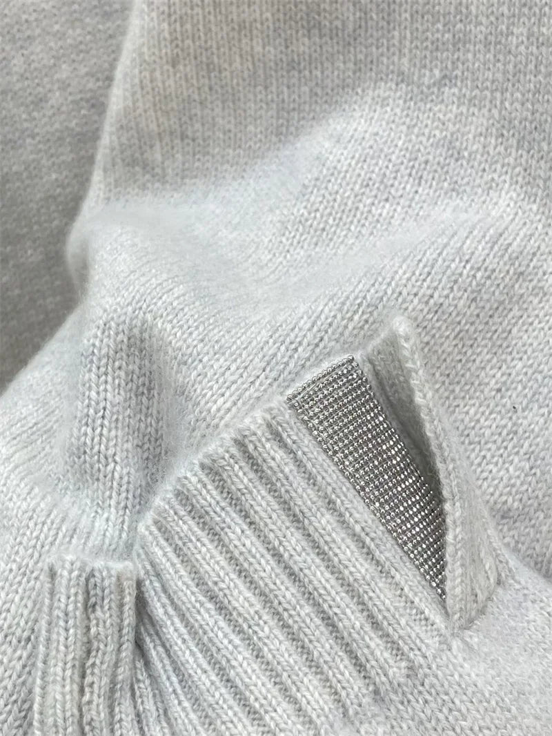 Close-up of ribbed cuff with subtle metal accent on Silver Sand cashmere sweater — From Borcelleclothes.