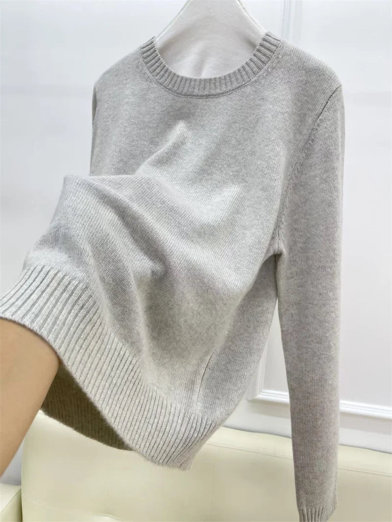 Women’s cashmere sweater in Silver Sand, shown on hanger with hand beneath to demonstrate drape — From Borcelleclothes.