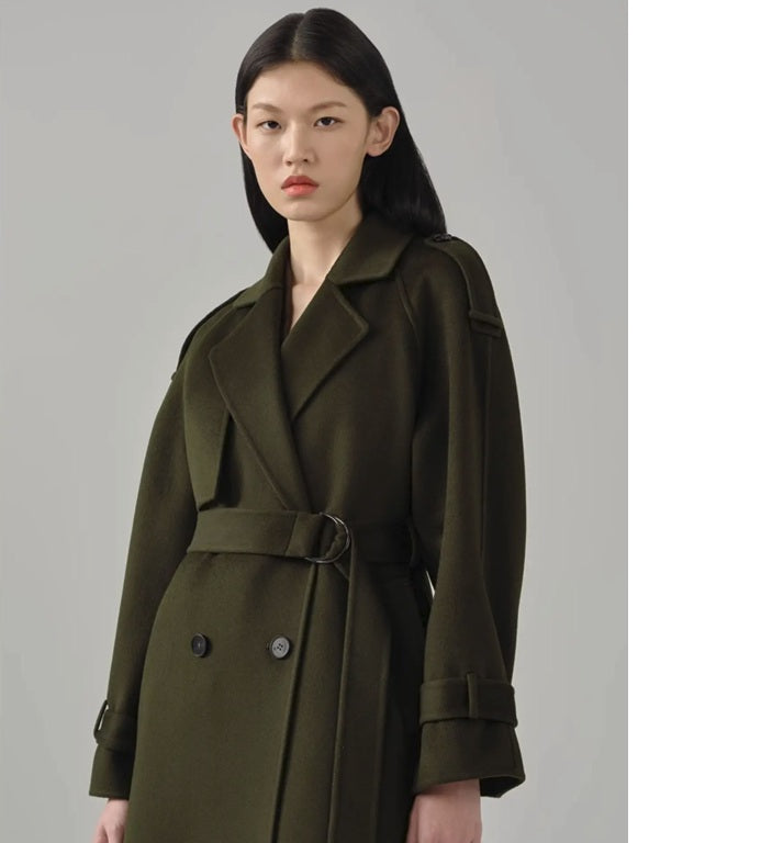 Model in the women's cashmere trench coat in Birch, slightly turned to the side, emphasizing the structured silhouette and elegant storm flap. From Borcelleclothes.