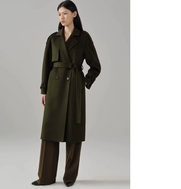 Model wearing the women's cashmere trench coat in Birch, gazing to the side and showcasing its tailored fit and classic design. From Borcelleclothes.