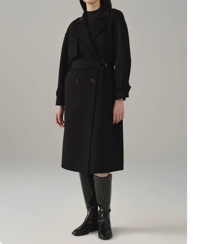 Model in the women's cashmere trench coat in Onyx, slightly turned to the side, highlighting the sleek design and luxurious cashmere fabric. From Borcelleclothes.