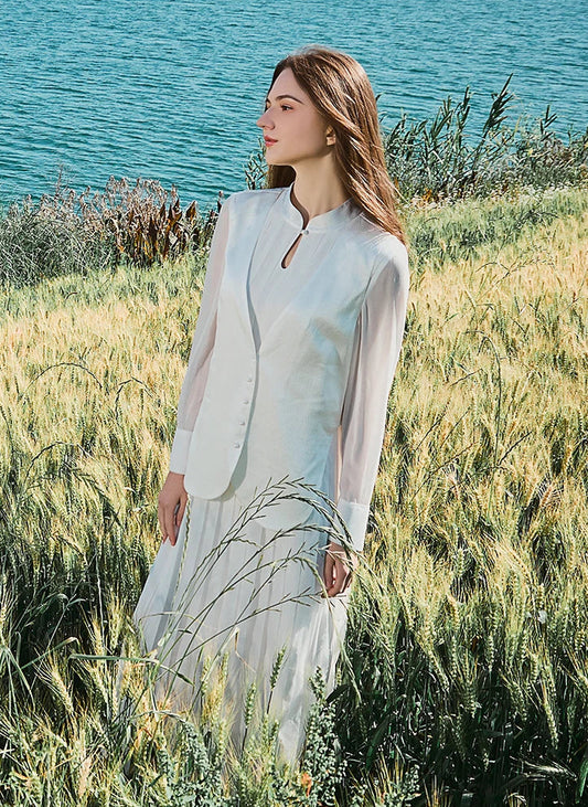 Model in in full ensemble, standing sideways in natural outdoor setting. From Borcelleclothes.