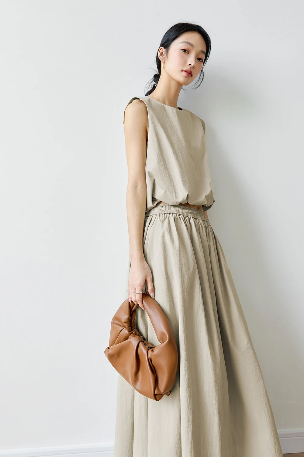 Woman slightly turned in Coral Reef set — gentle drape of the top and skirt captured in quiet motion. From Borcelleclothes.