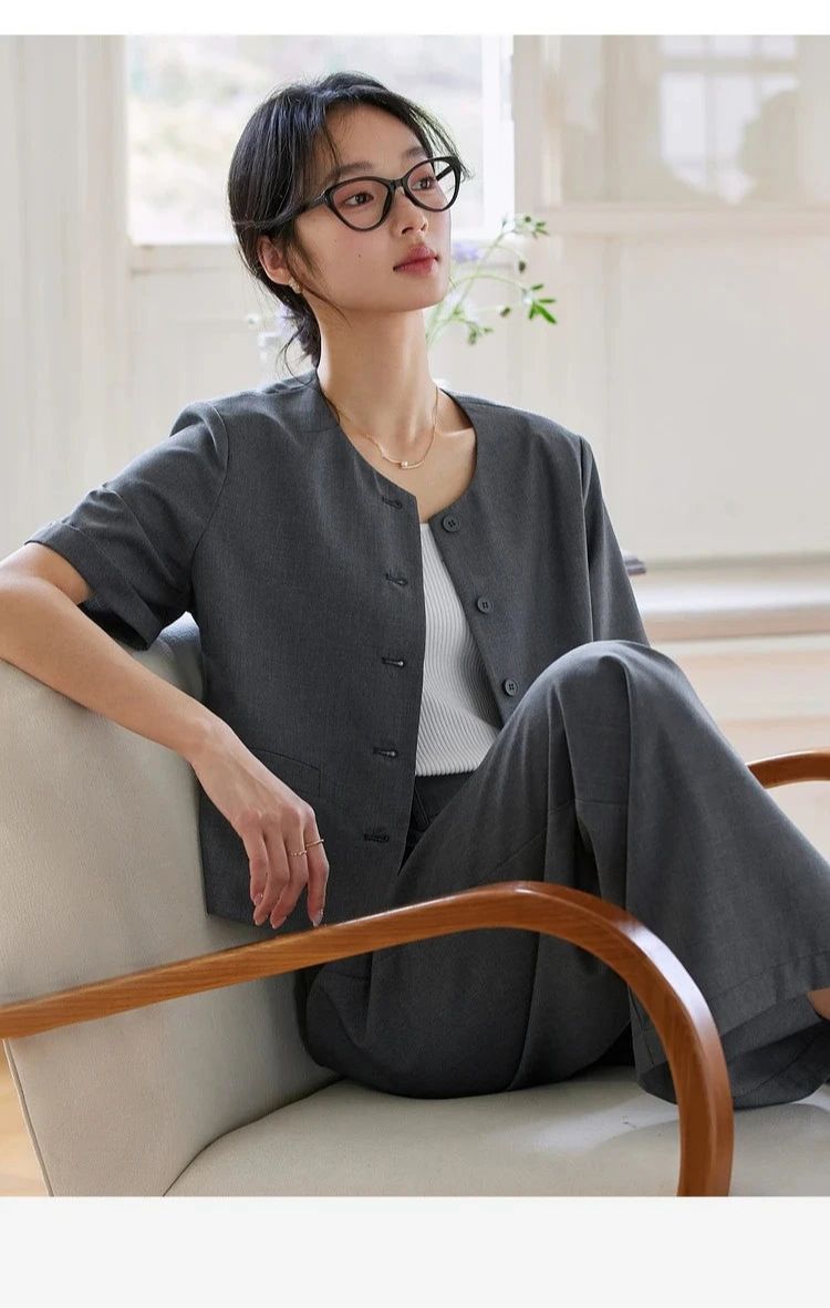 Model sitting in an armchair with bent leg folded inward wearing the Fiord set. From Borcelleclothes.