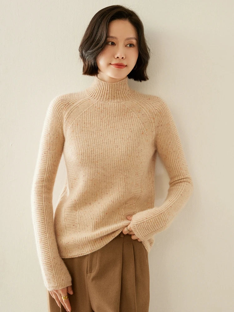 Spiced Latte cashmere sweater gently held by the model at the bottom hem, highlighting its structured softness — From Borcelleclothes.